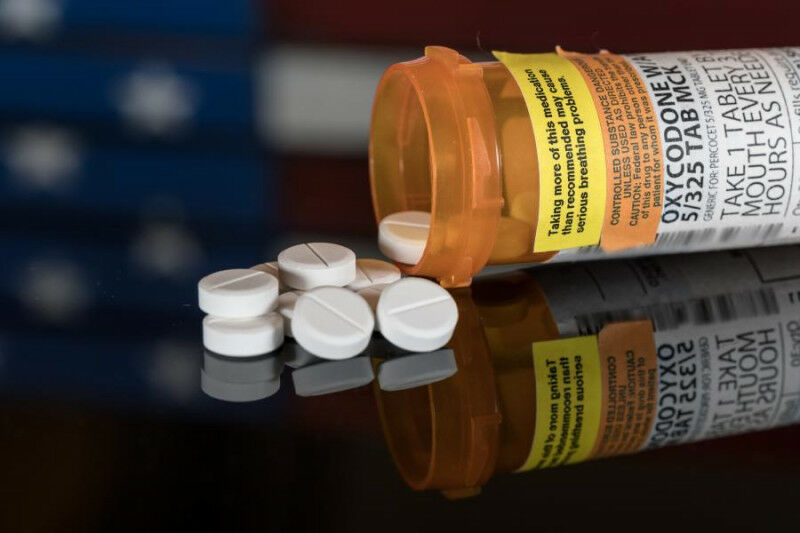 Frasco de prescrição para comprimidos e pílulas de oxicodona em mesa de madeira com EUA fla