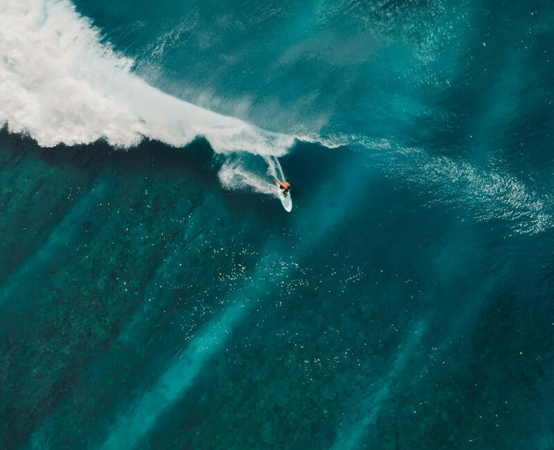 Uma vista aérea de um surfista pegando uma onda