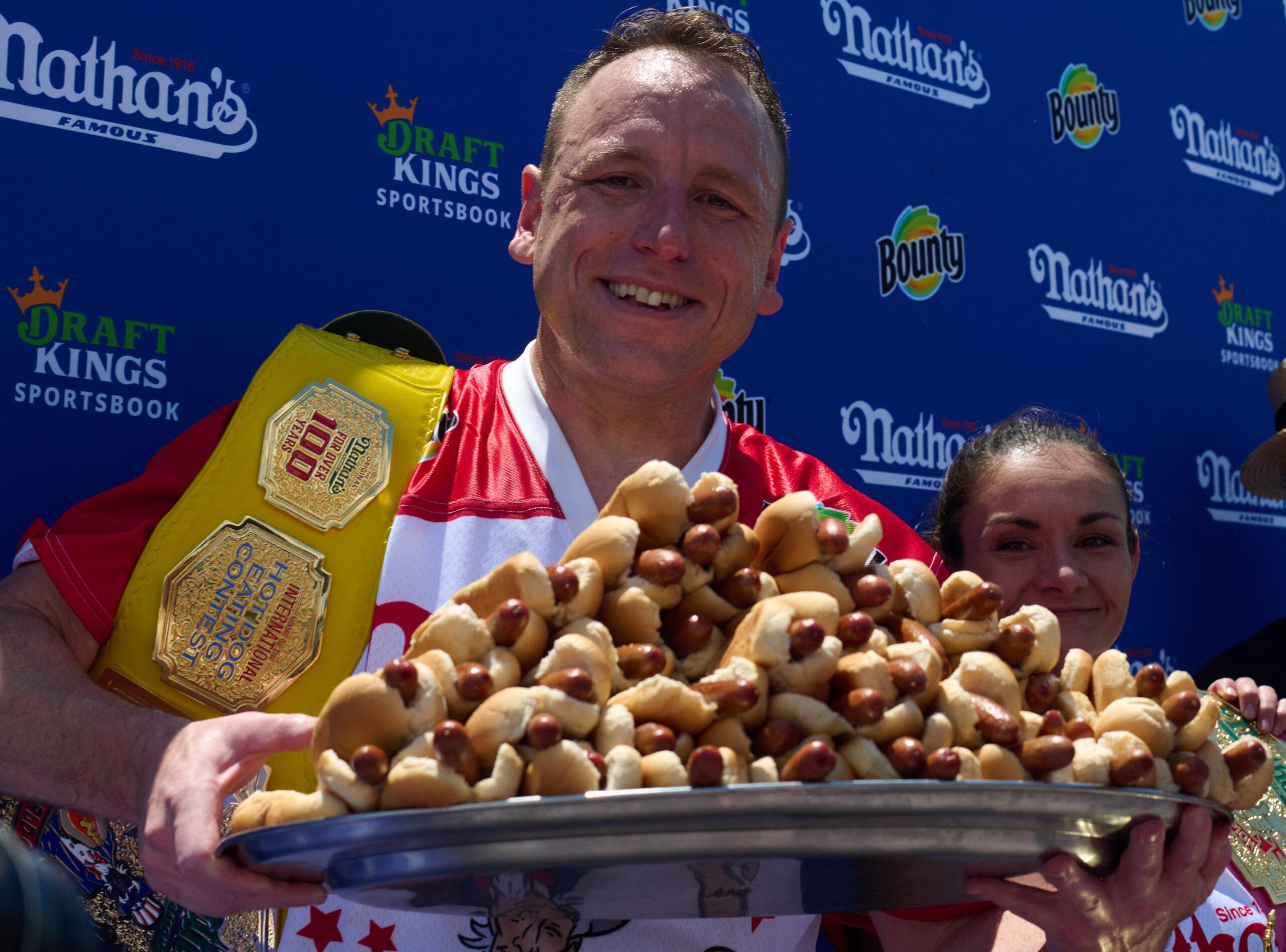 Joey Chestnut segurando um prato de cachorro-quente