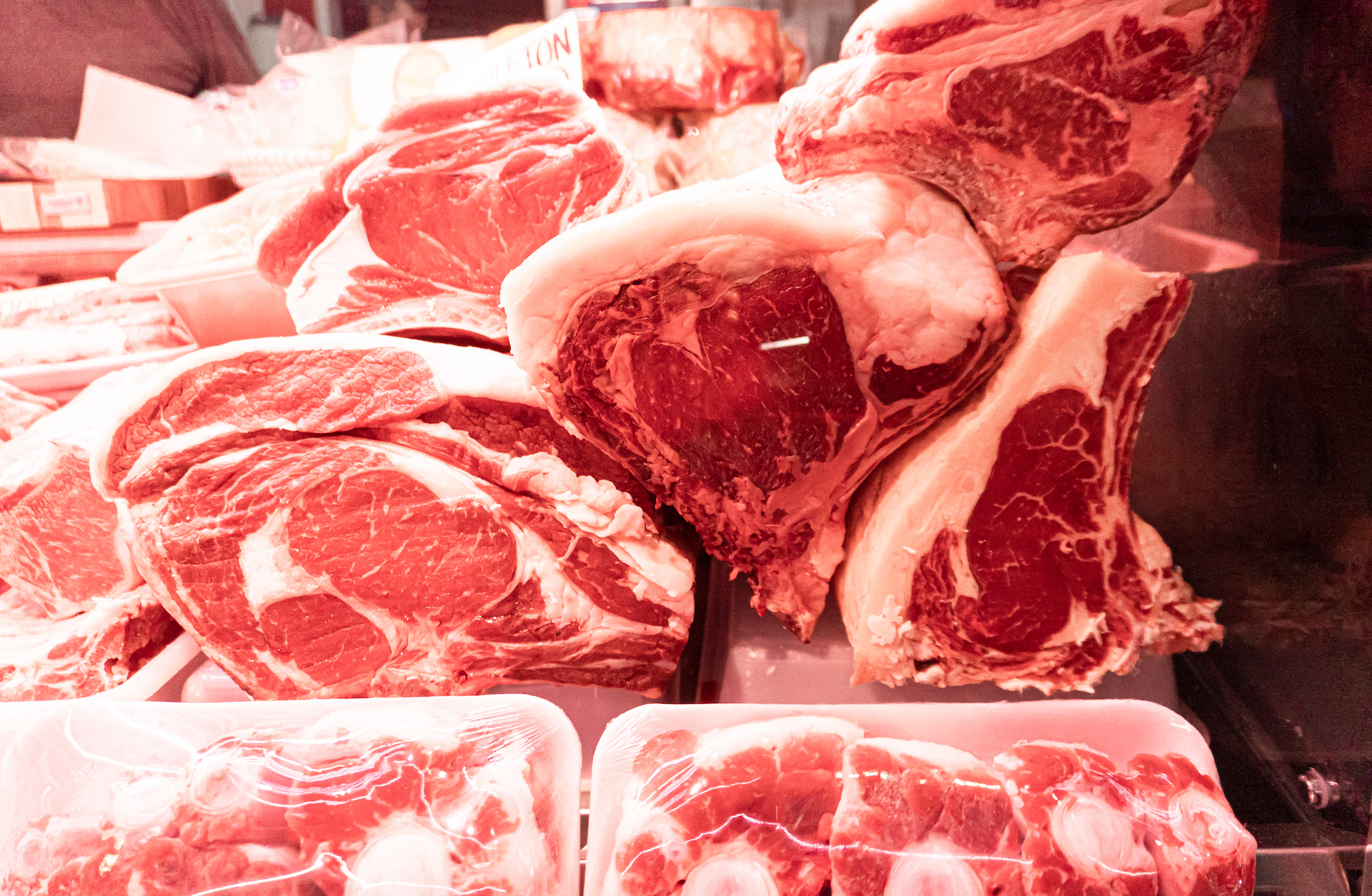 A photo of a pile of steaks at the butcher