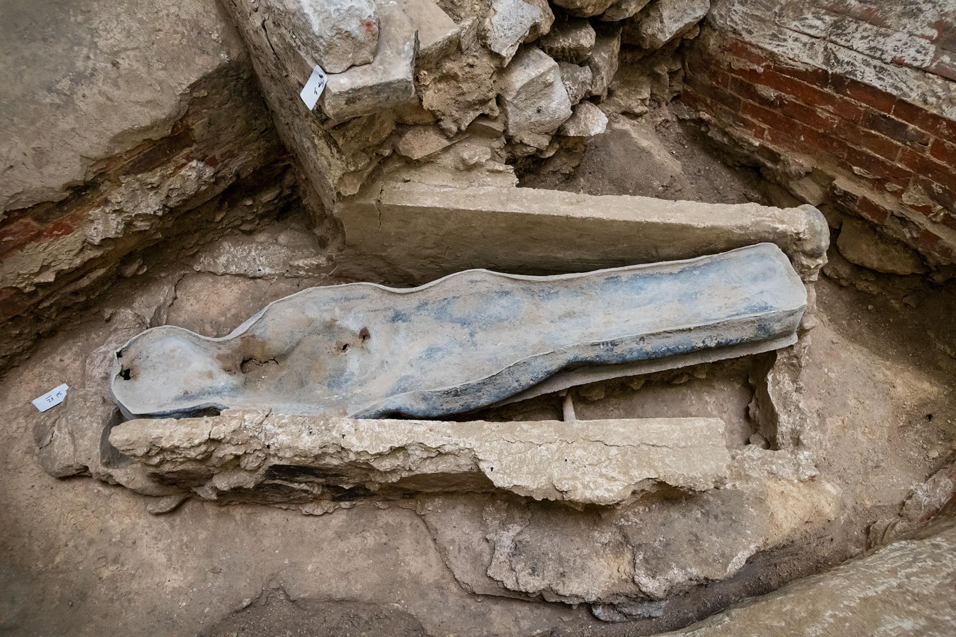 Uma foto olhando para um sarcófago de chumbo em forma humana em um cemitério sob o piso de Notre Dame.