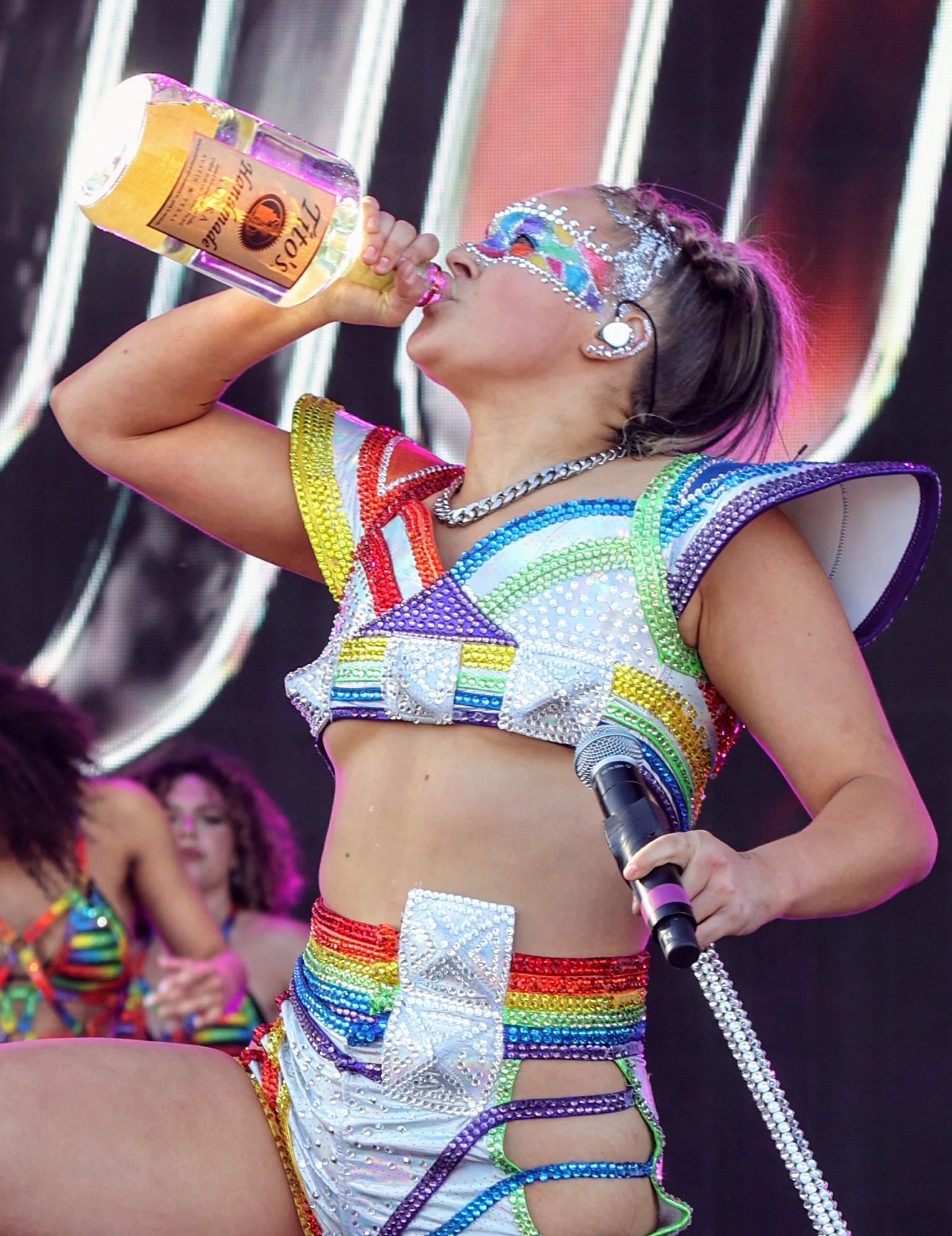 Jojo Siwa bebe uma garrafa de vodka Titos no palco