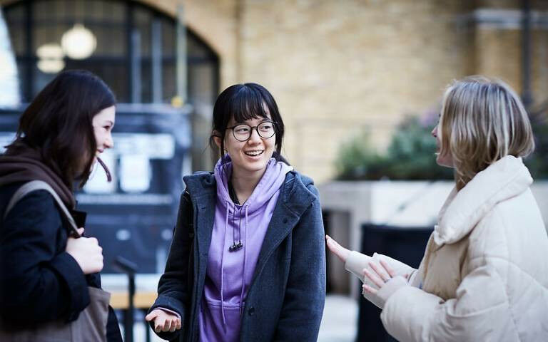 Três mulheres conversando no Wilkins Terrace na UCL