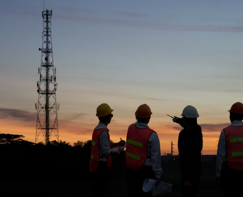 Três engenheiros de telecomunicações olhando para satélites