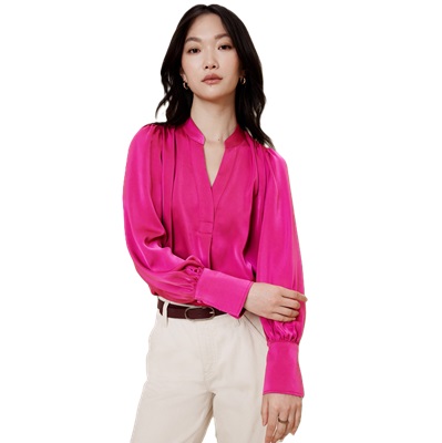 Uma mulher vestindo uma blusa rosa brilhante, calça esbranquiçada e faixa marrom